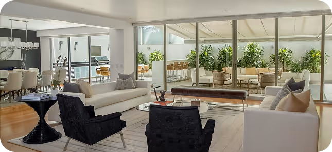 Living room with black and white sofas, and big windows showing the backyard.