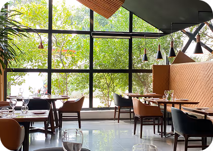 Set-up tables at a restaurant with wine glasses and plates.
